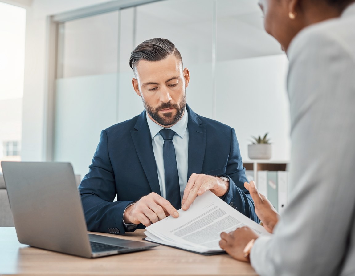 An attorney going through a document with a client across the desk